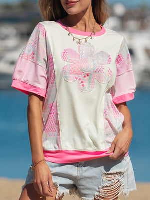 Maternity t-shirt with floral patchwork, crew neck, short sleeves, and pink accents.