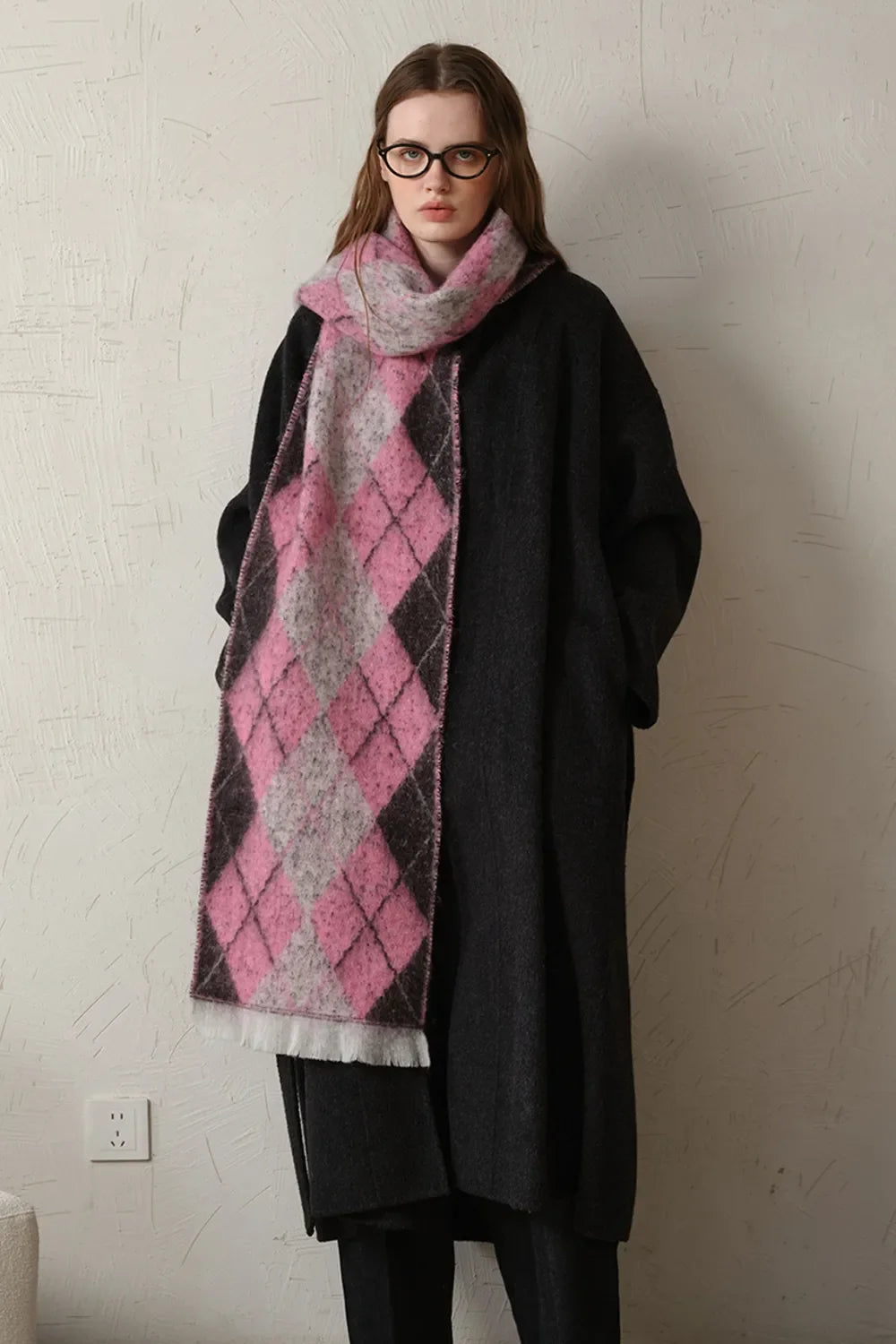 Argyle knit scarf in pink, grey, and black with fringe detail.