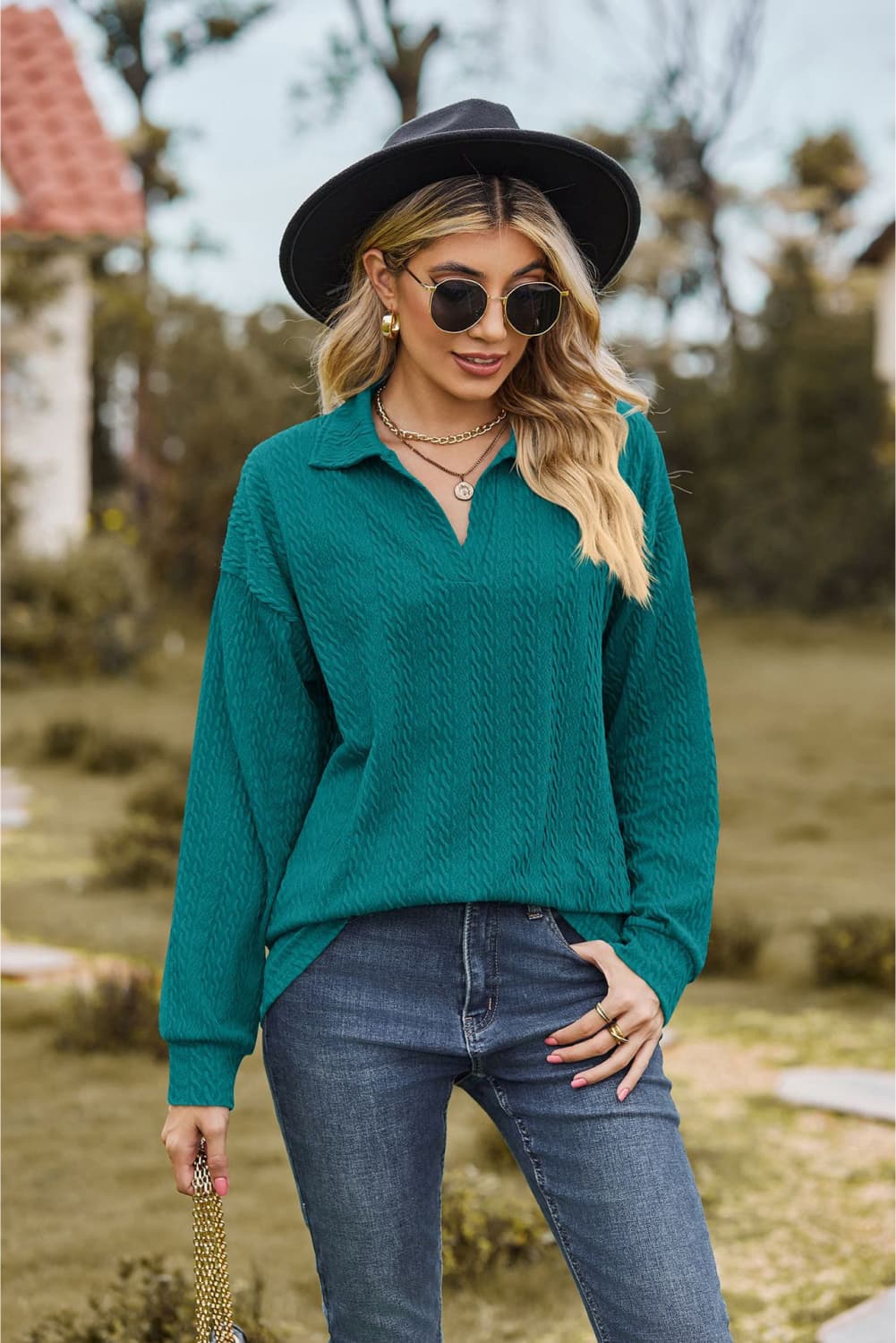 Turquoise textured cable knit polo top with a v-neck and long sleeves.
