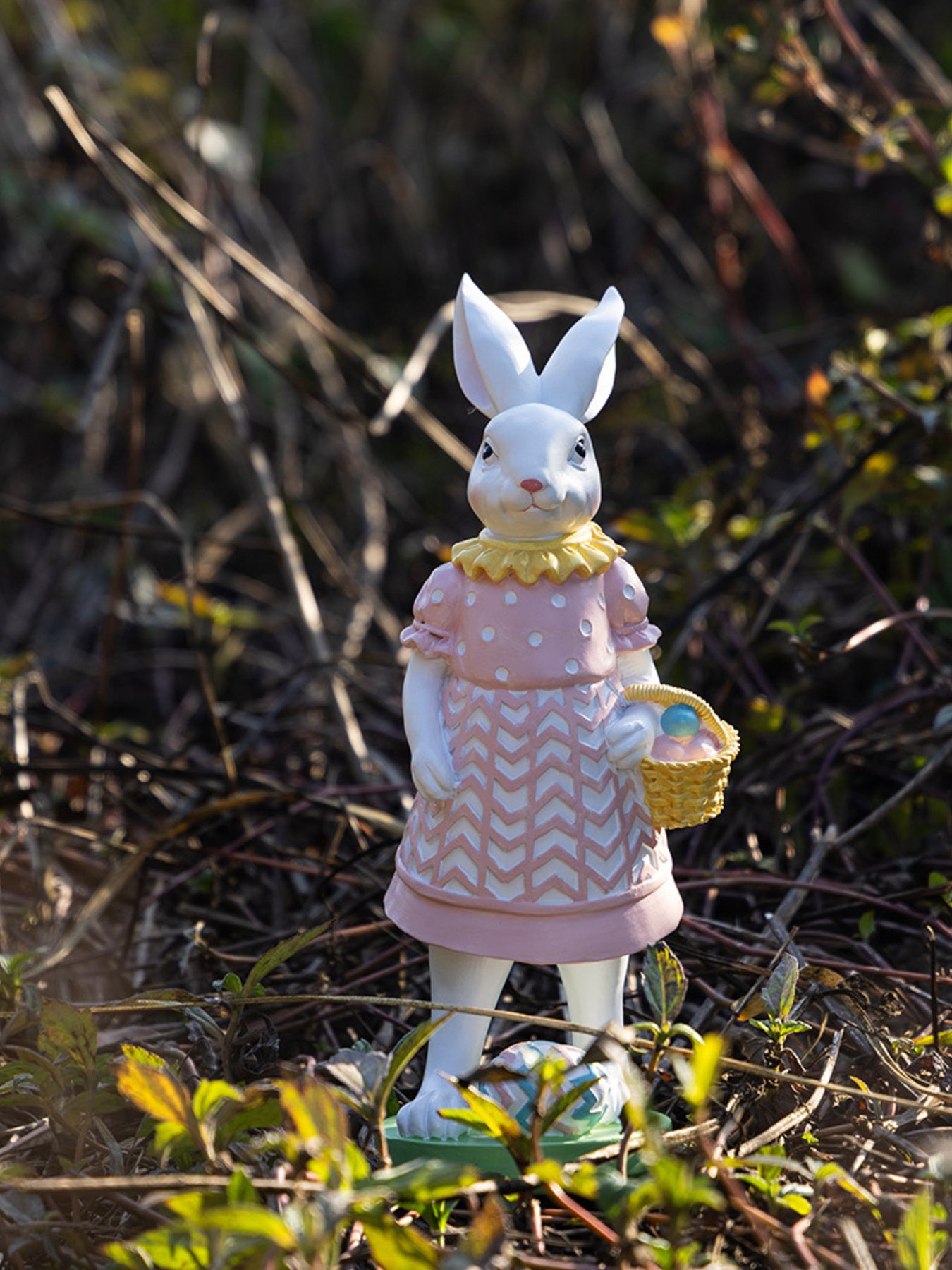 Blush pink Easter bunny ornament in a polka dot dress holding a basket of eggs.