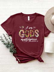 Burgundy graphic tee with floral typography reading "I am GOD'S masterpiece" and Ephesians 2:10.