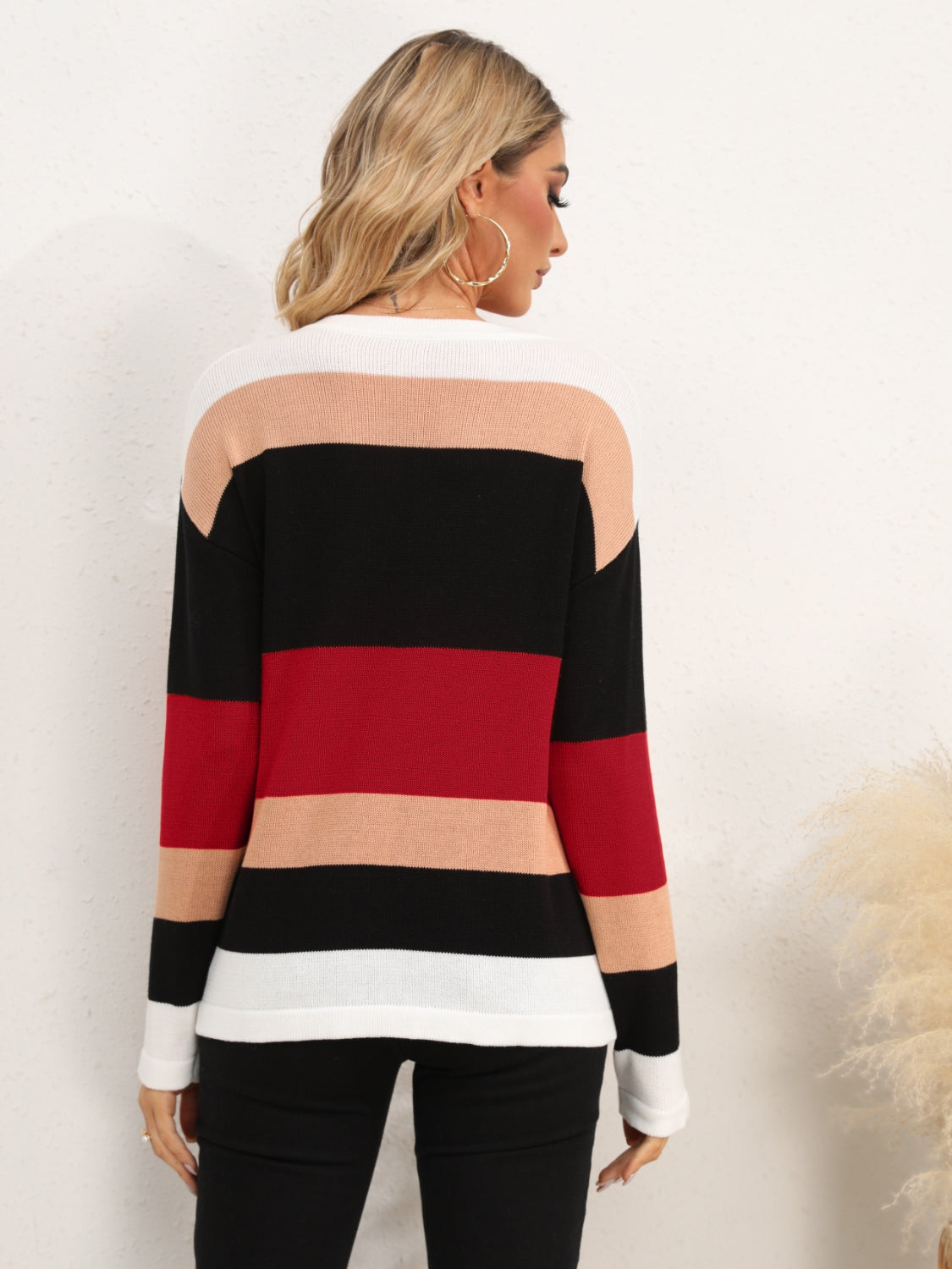 Colorblock crewneck sweater with horizontal stripes in black, red, tan, and white.