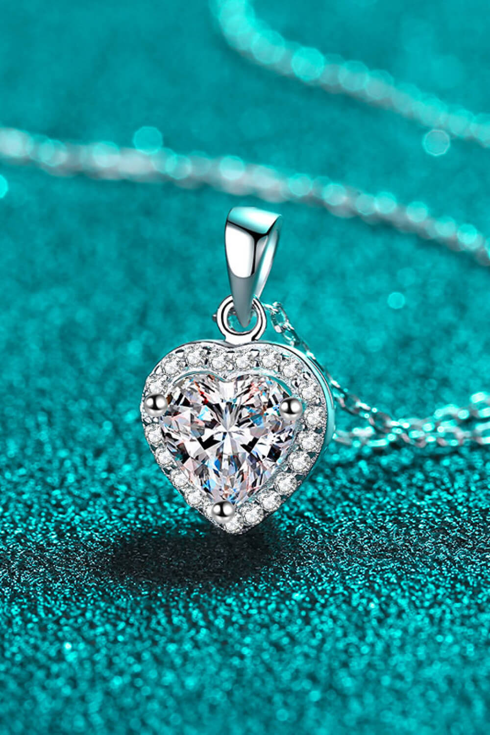 Silver heart cut halo pendant necklace with clear cubic zirconia on a sterling silver chain.