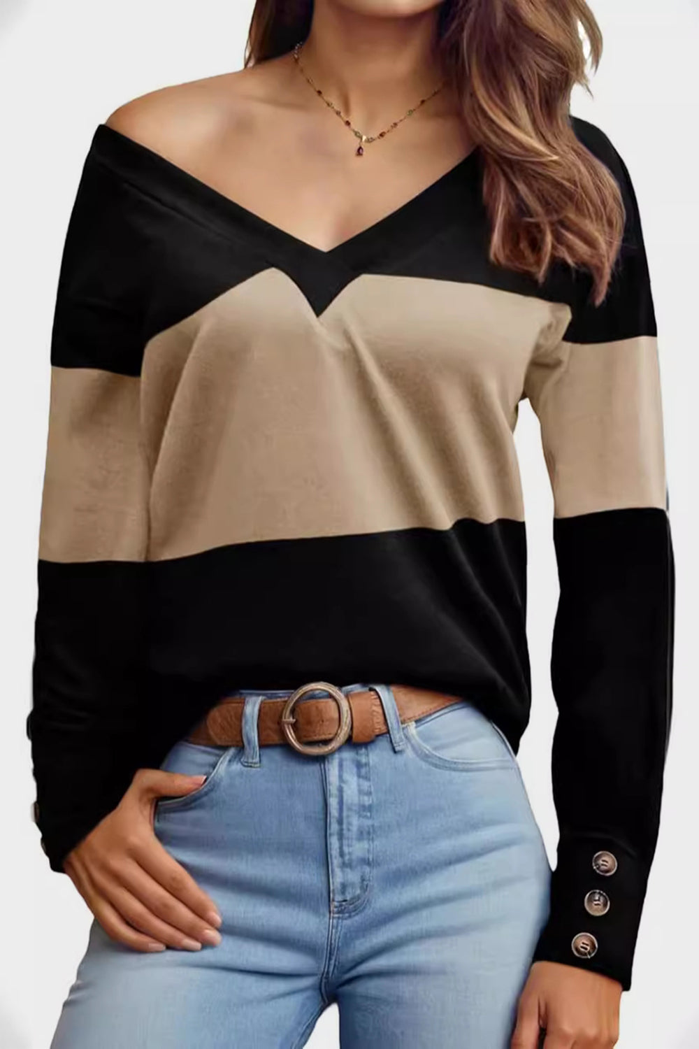Geometric V-neck sweater in black and camel with button cuffs.