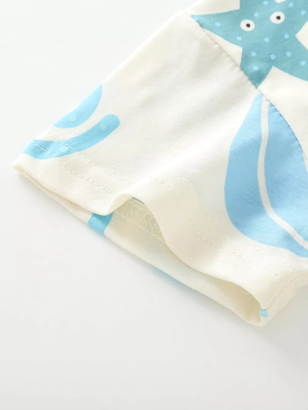 Baby t-shirt with playful blue ocean creature graphic on cream cotton, short sleeves.