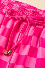Hot pink checkered loungewear shorts with drawstring and gold tips.