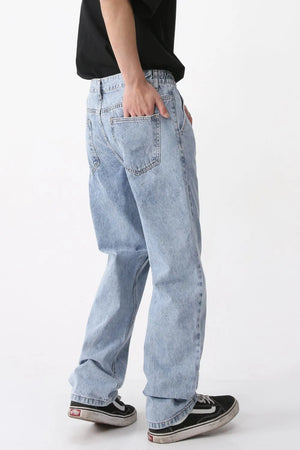 Pleated denim wide-leg trousers in medium wash, featuring a relaxed fit and casual styling.