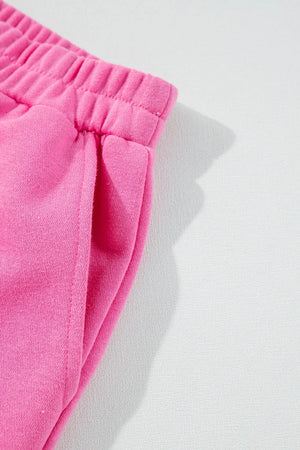 Fuchsia pink cotton loungewear pants with elastic waistband and side pocket detail.