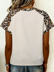 Beige short sleeve blouse with leopard print raglan sleeves and crew neck.