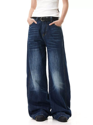 Belted wide leg jeans in washed denim with a relaxed fit and subtle whiskering.