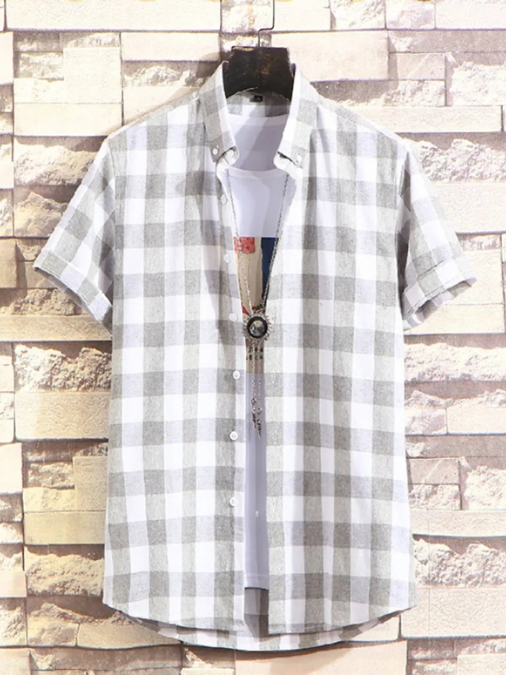 Men's gray plaid short sleeve buttoned shirt with white undershirt.
