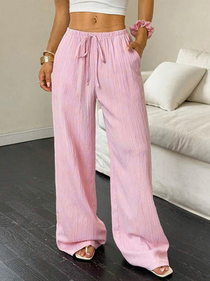 Crinkled wide leg pants in pink with drawstring waist and pockets.