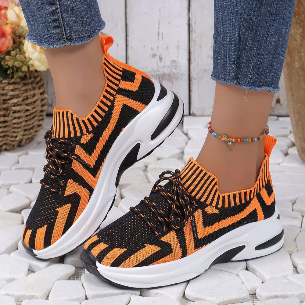 Orange and black geometric knit platform sneakers with white soles and laces.