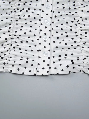 White polka dot t-shirt with ruched sides and button front detail.