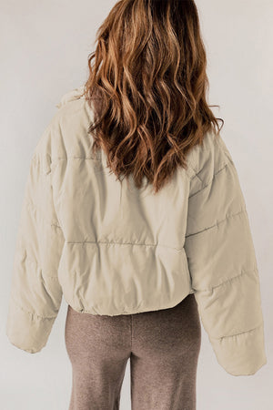 Cream cropped puffer jacket with hooded collar and horizontal quilting.