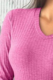 Ribbed knit V-neck top in fuchsia pink with long sleeves.