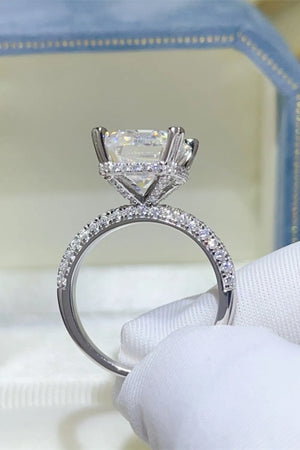Emerald cut moissanite ring with pave diamond band in silver.