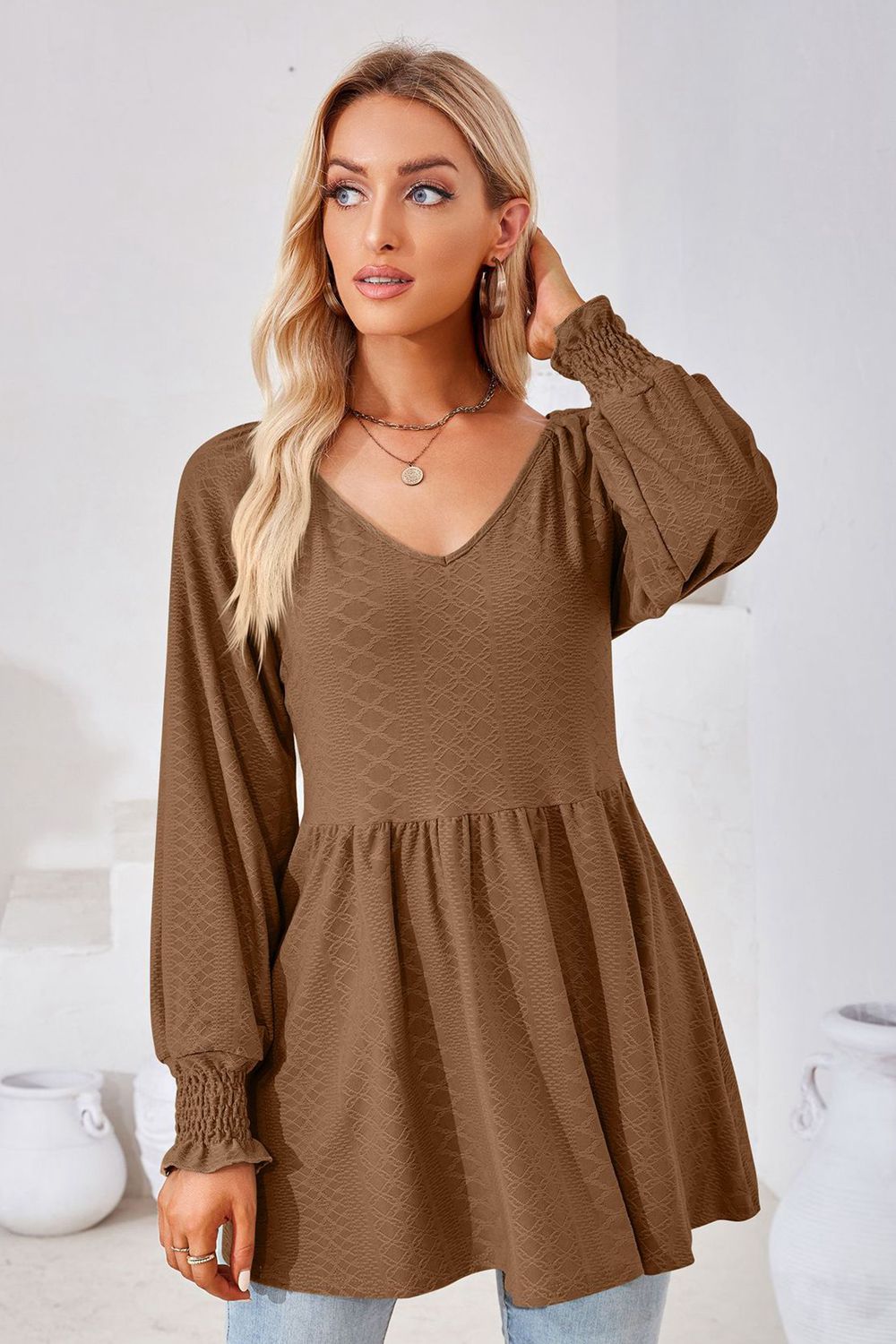 Brown textured babydoll blouse with V-neck and smocked cuffs