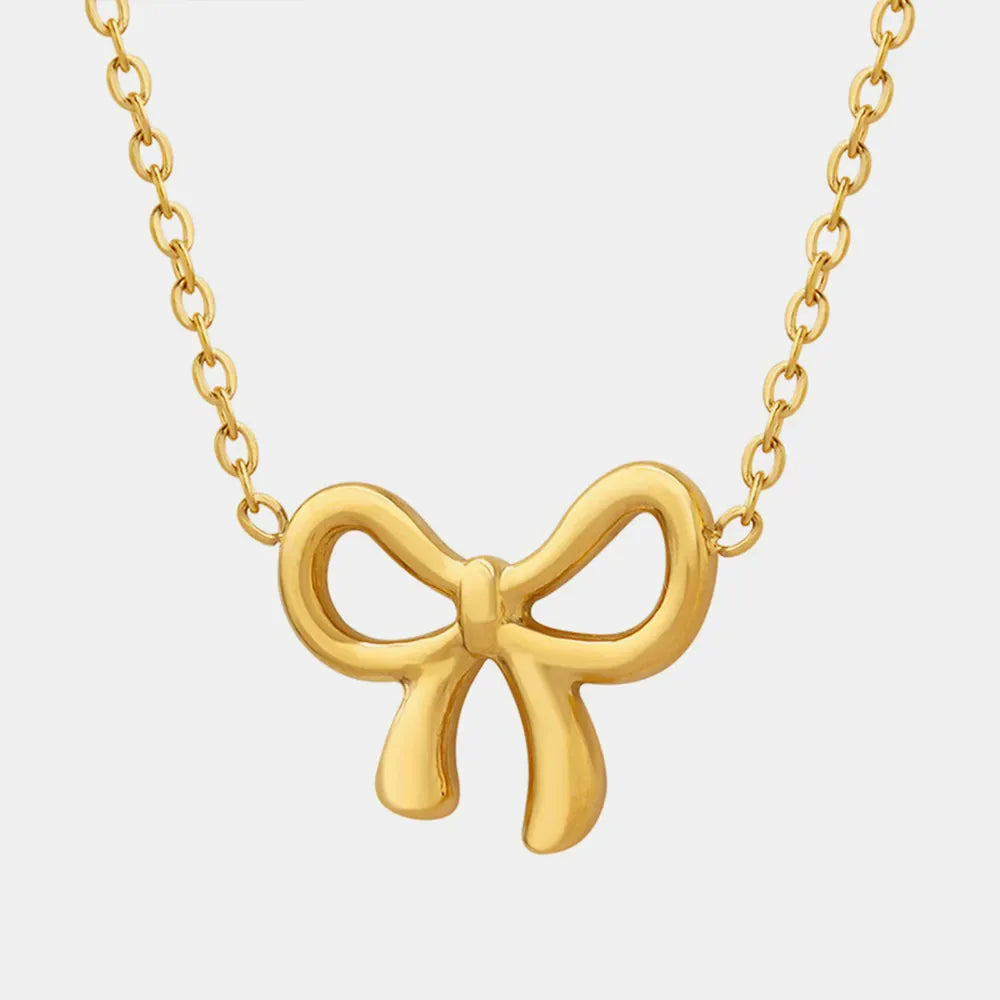 Delicate gold bow pendant necklace with a fine chain.