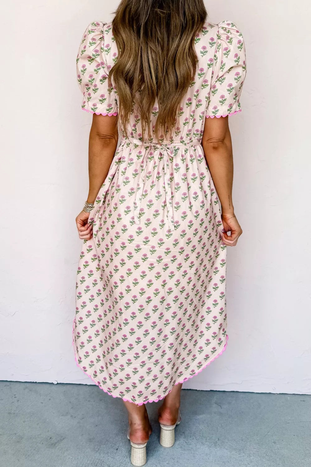 Floral V-neck midi dress in blush pink with scalloped trim and tie waist.