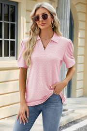 Pink perforated polo top with short puff sleeves and a v-neck.