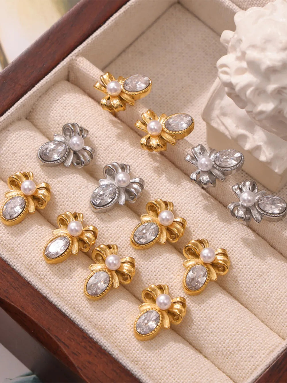 Gold and silver bow stud earrings with pearl and crystal details