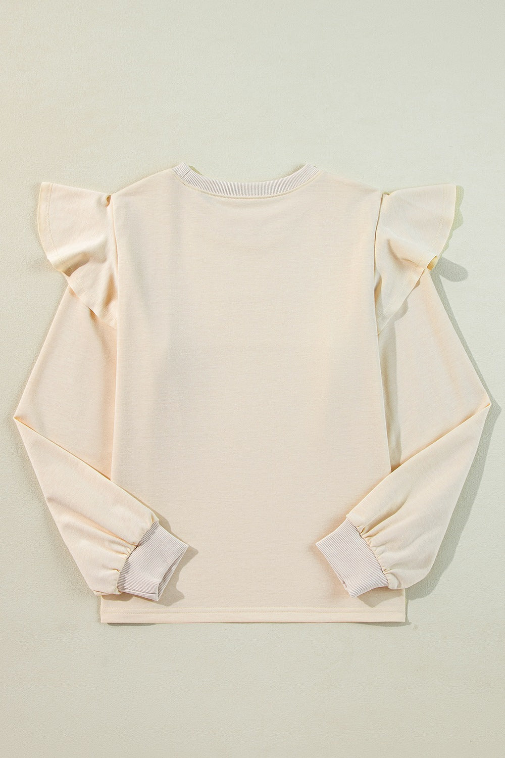 Cream ruffled shoulder sweatshirt with ribbed cuffs and crew neck.