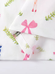 Toddler dress with pink bows and green foliage print on white cotton fabric.