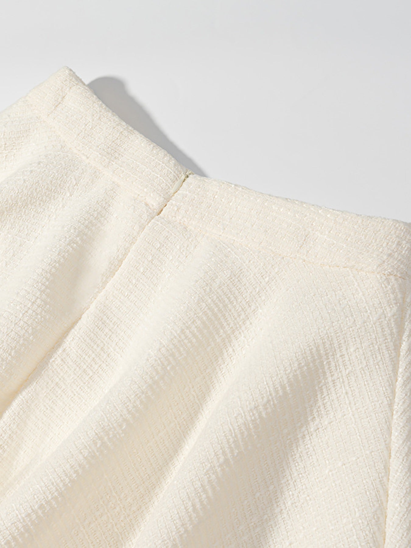Textured cream button-down top with a visible zipper detail