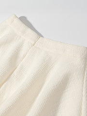 Textured cream button-down top with a visible zipper detail