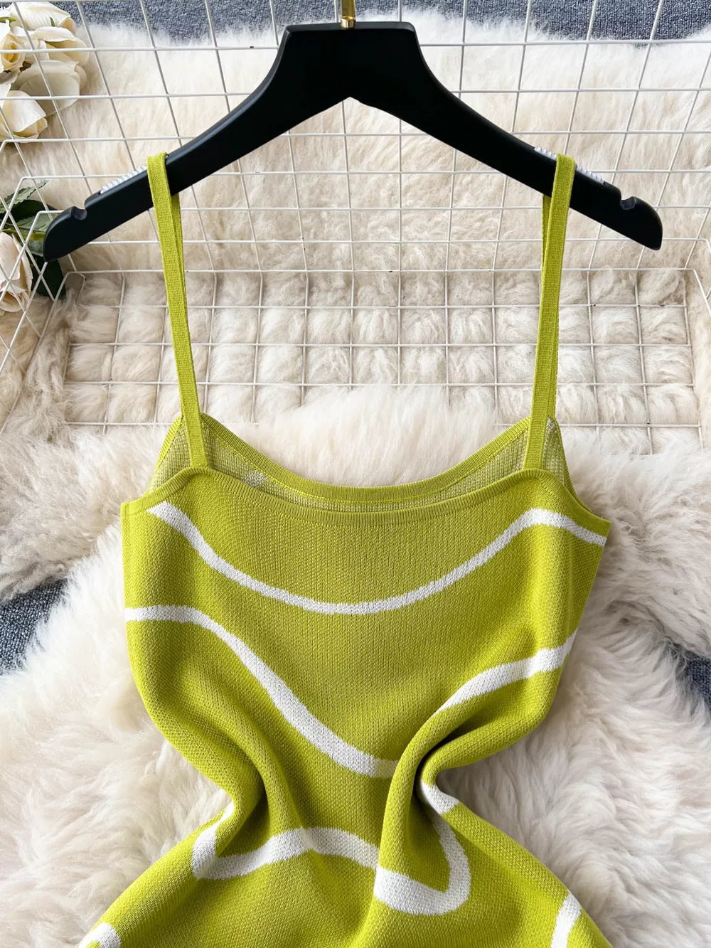 Green wavy knit midi dress with spaghetti straps and a bodycon fit.