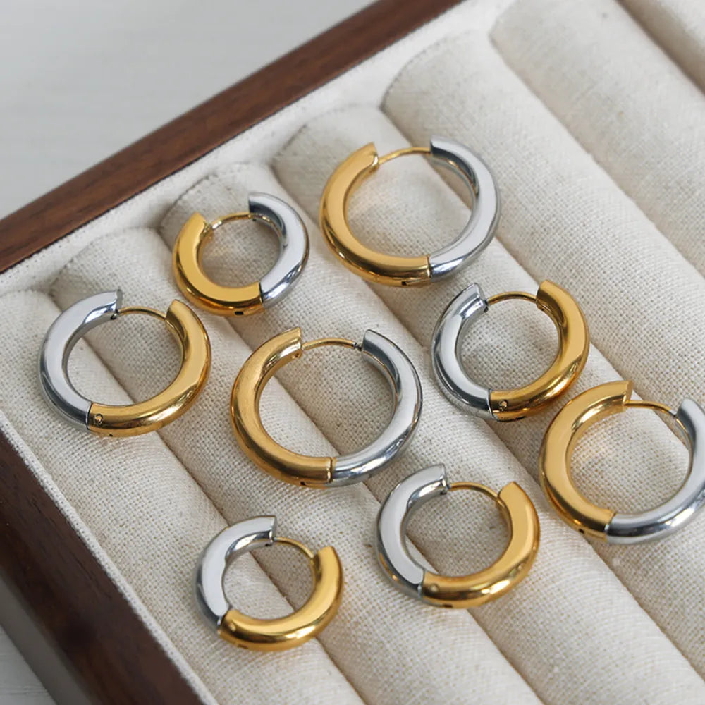 Two-tone segmented hoop earrings in gold and silver metal.