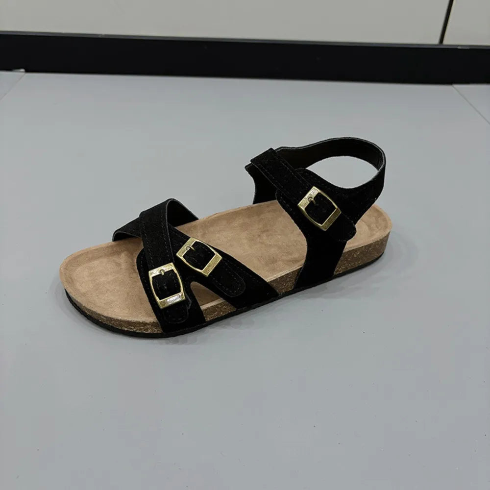 Black suede crossover buckle cork sandals with ankle strap.