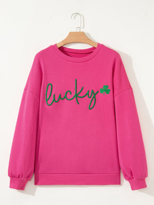 Pink crew neck sweatshirt with green embroidered lucky clover graphic