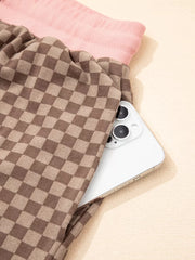 Chic checkerboard loungewear shorts in brown with a pink waistband, showing a phone pocket detail.