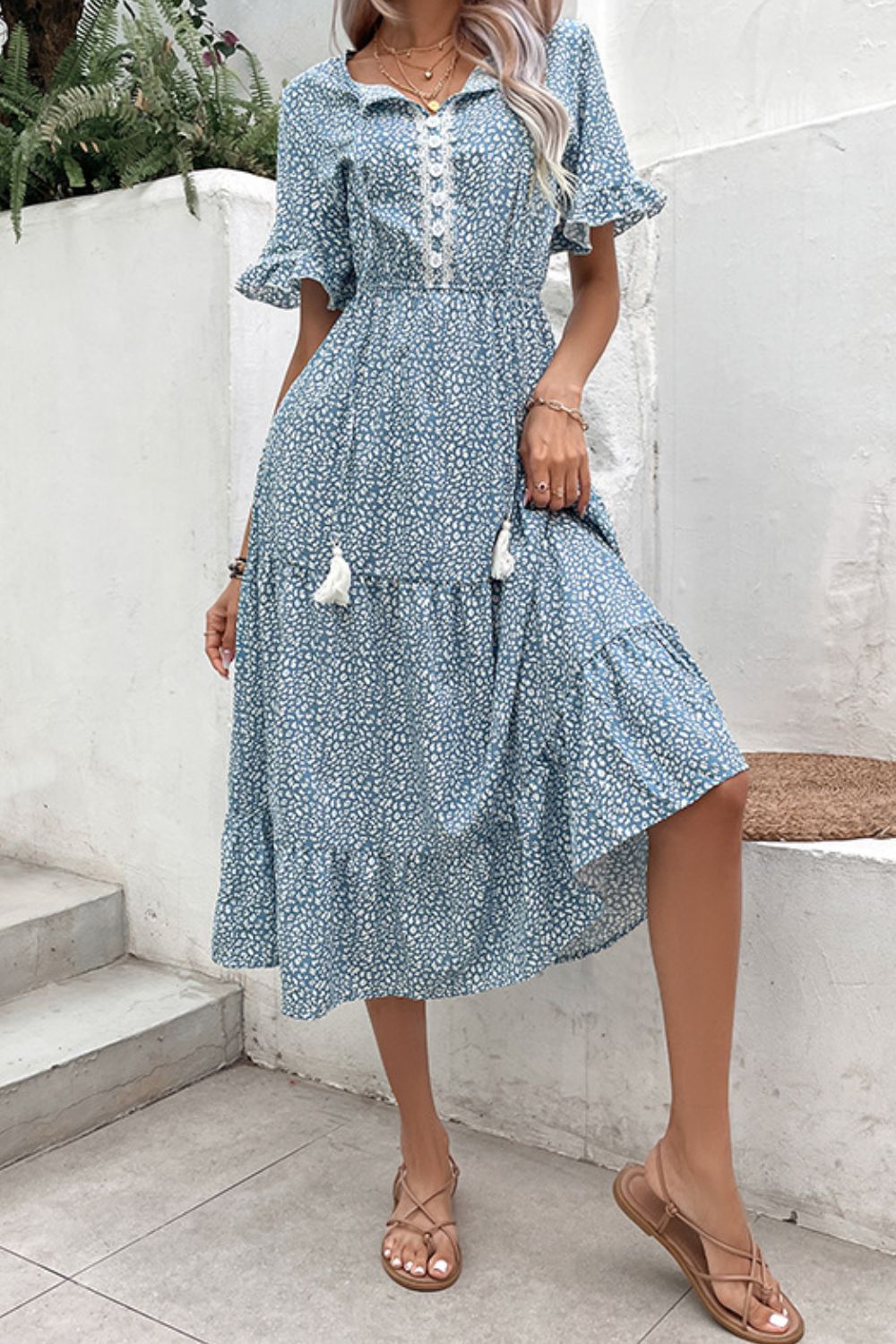 Light blue floral midi dress with tiered skirt, lace trim, and tassel details.