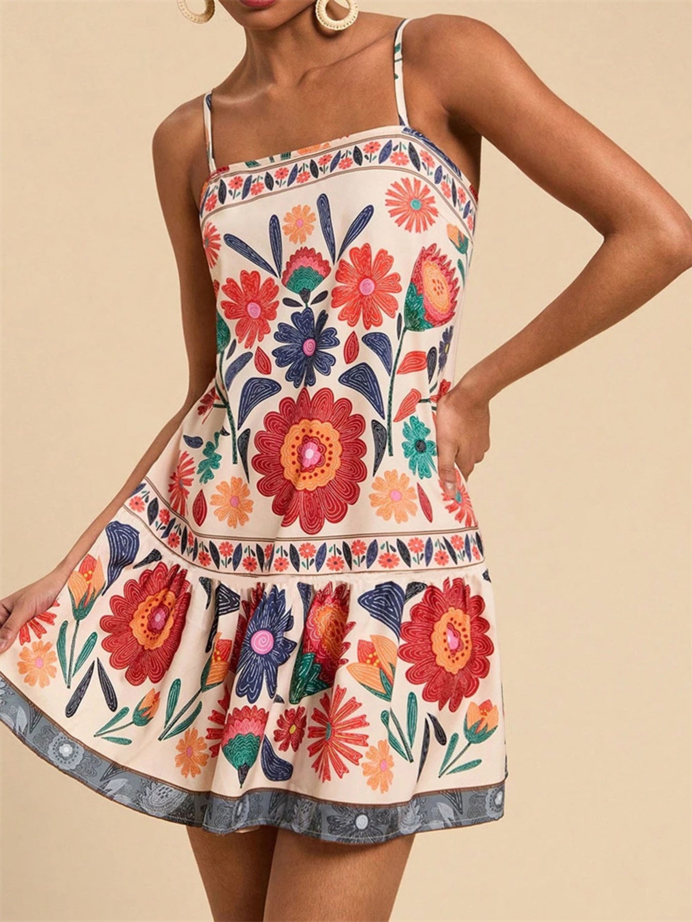 Playful floral print mini dress with spaghetti straps and a tiered hem.