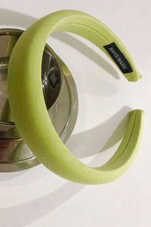 Padded headband in Matcha Green textured fabric with a black "HANDMADE" tag.