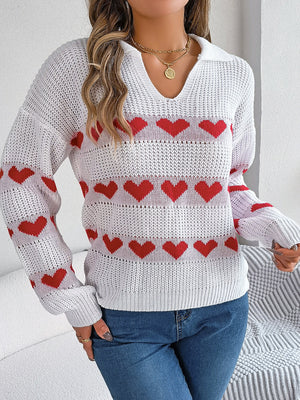 White knit polo sweater with red heart stripe pattern and open knit details.