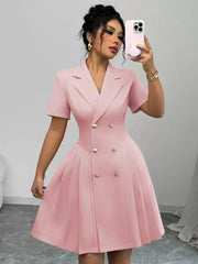 Blush pink double-breasted pleated blazer dress with gold buttons and short sleeves.
