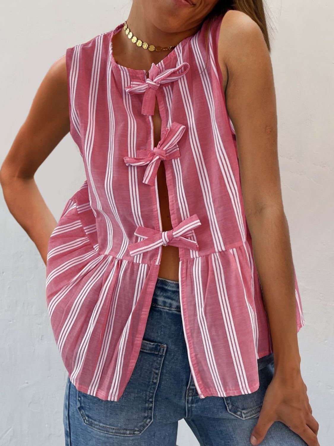 Fuchsia pink striped peplum top with bow tie closures and a ruffled hem.
