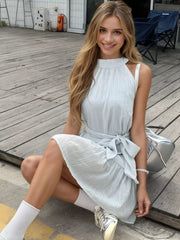 Sky blue mini dress with halter neckline, tie waist, and subtle pinstripe detail.