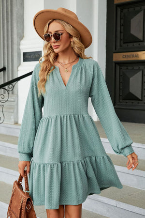 Light green textured babydoll mini dress with voluminous sleeves and tiered hem