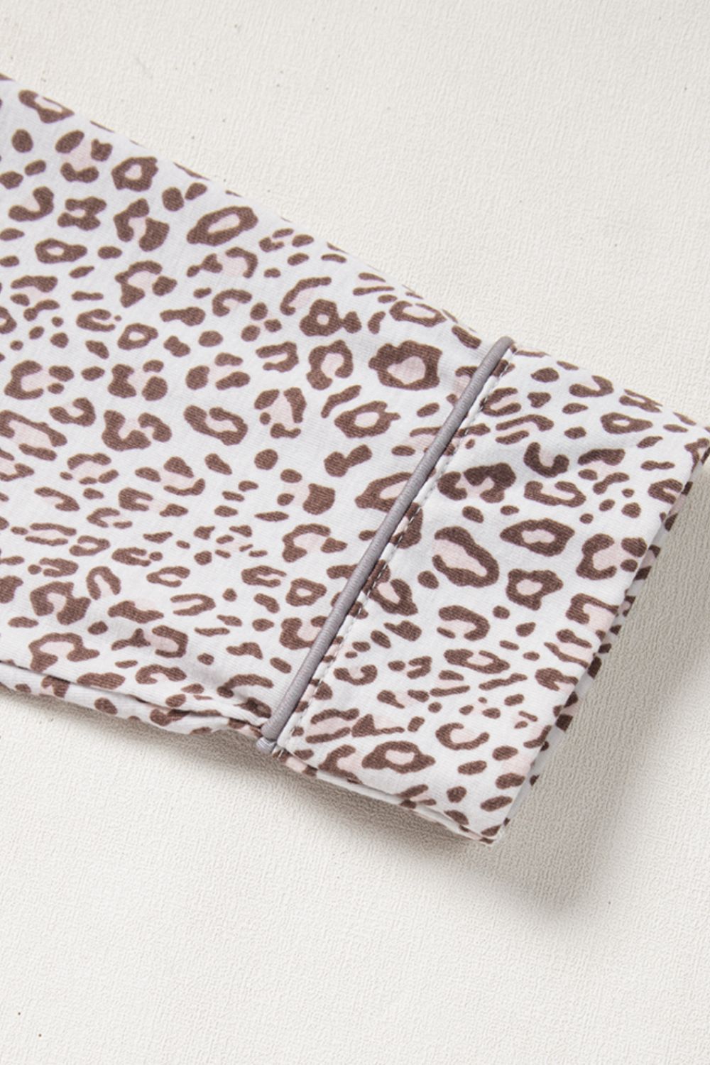 Leopard print pajama set with button-down detail and grey piping on cuff.