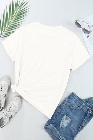 White cotton t-shirt with rolled sleeves and a knotted hem, styled with denim shorts.