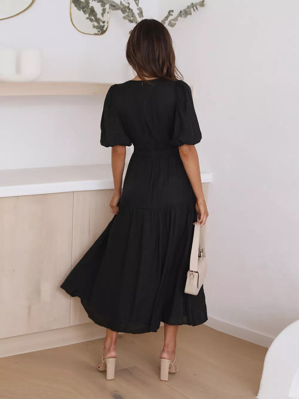 Black puff sleeve midi dress with tiered skirt and cinched waist.