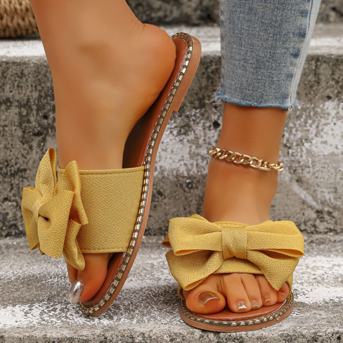 Yellow bowknot slide sandals with beaded trim.