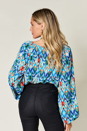 Prismatic ikat blouse in blue with voluminous sleeves and a scoop neck.