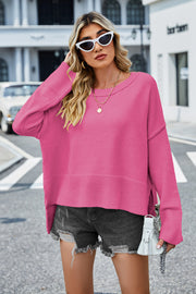 Hot Pink acrylic knit sweater with flared sleeves and slit hem detail.