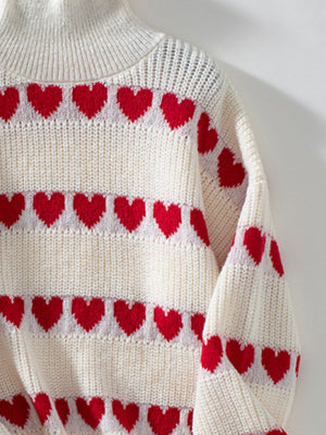 Cream turtleneck sweater with red heart intarsia pattern and ribbed details.